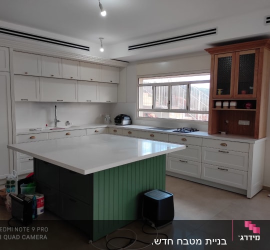 מטבח עם אי ירוק, ארונות לבנים וכיריים גז